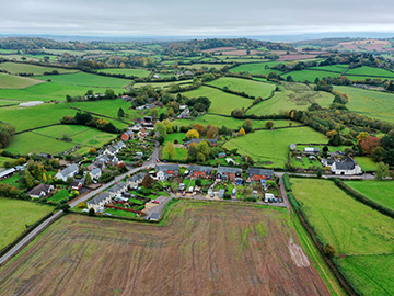 rural landscape with green fields, farms, and a small grouping of homes